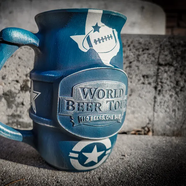 Ceramic beer mug coated in distressed blue Cerakote with white star and football graphics.