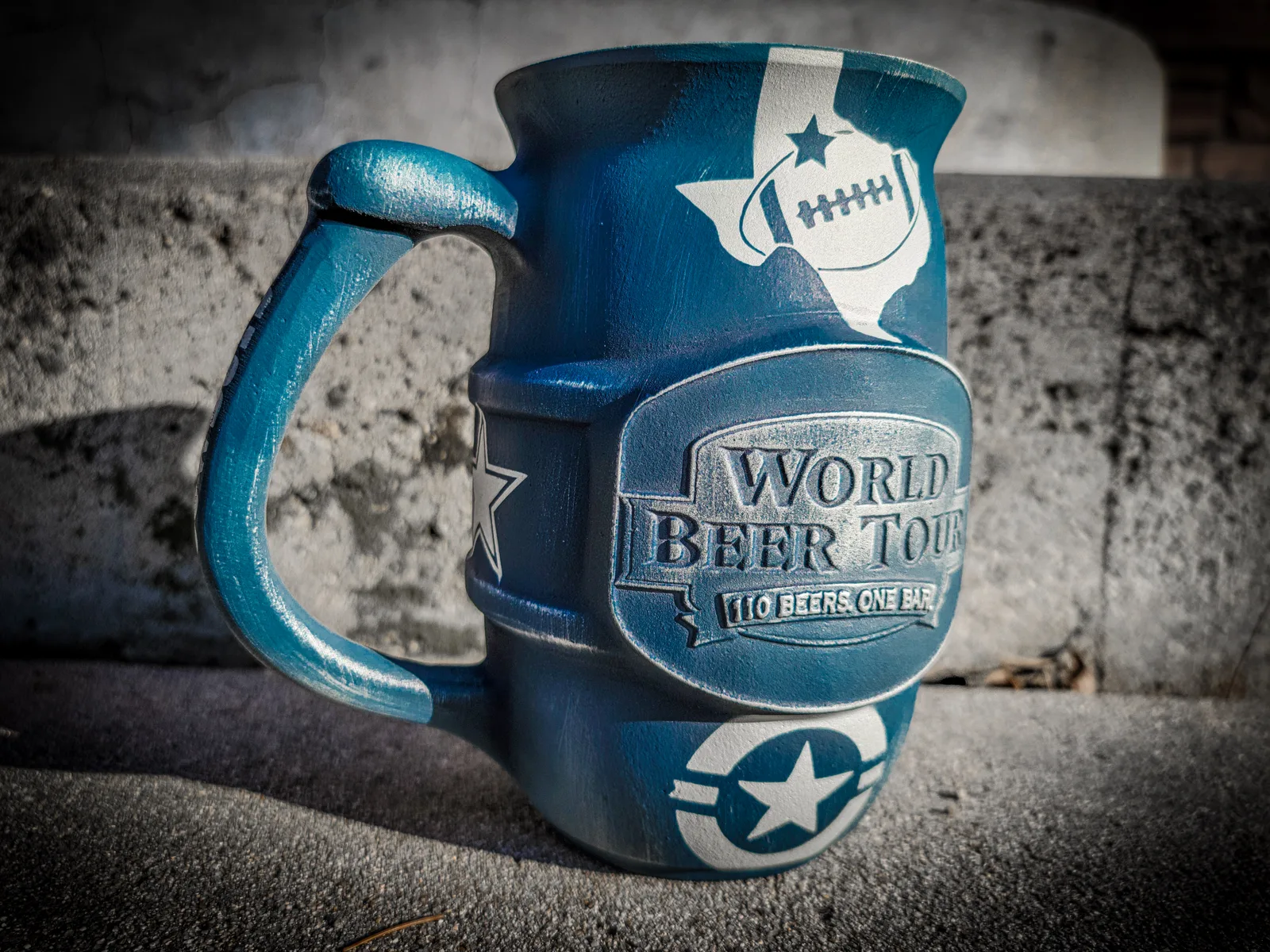 Ceramic beer mug coated in distressed blue Cerakote with white star and football graphics.