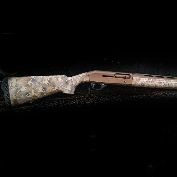 Semi-automatic shotgun with a burnt bronze receiver and light camo stock in Cerakote.