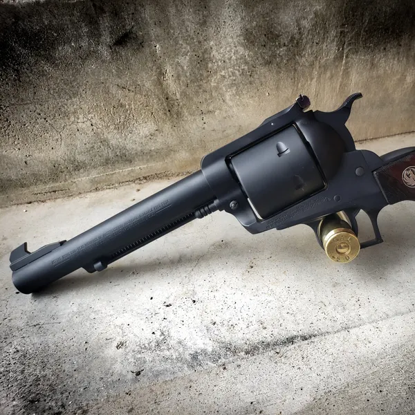 Long-barreled single-action revolver in a matte black Cerakote finish with wood grips.